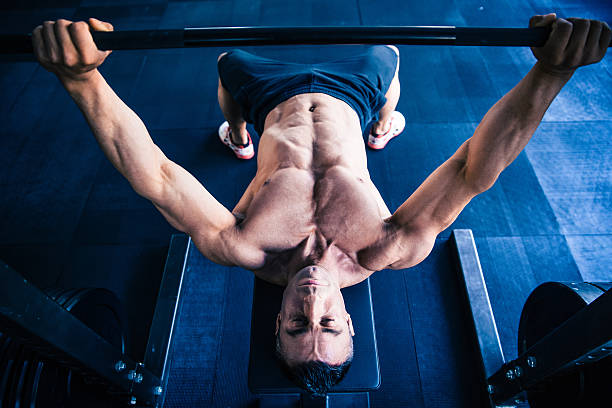 istock Muscular man workout with barbell on bench 470784346