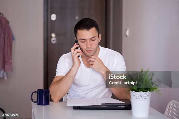 Junger Mann Spricht Am Telefon Stockfoto und mehr Bilder von Arbeiten - Arbeiten, Berufliche Beschäftigung, Büro