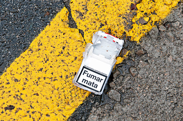 Health authorities advise that smoking kills Empty cigarette pack discarded on street in Barcelona with message in Catalonian that the health authorites advise that smoking kill empty-cigarette-packs stock pictures, royalty-free photos & images