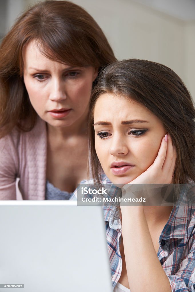 A mother and daughter looking at a laptop Concern for parents in the online age Child Stock Photo