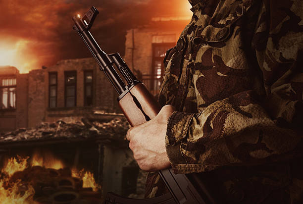 istock Soldier is holding gun on apocalyptic background 470785466