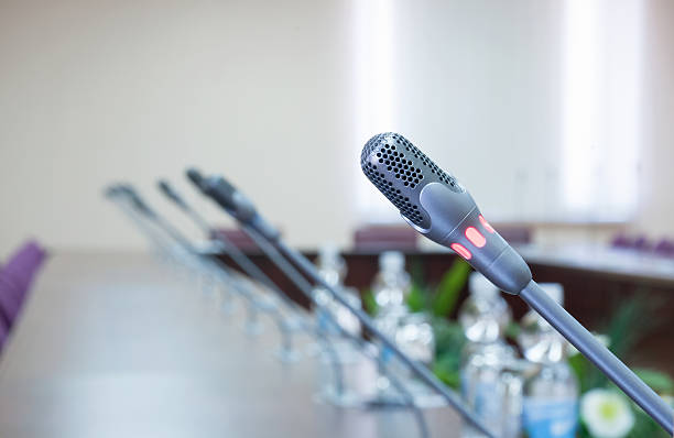 conference hall close up of a microphone in empty conference hall shareholders meeting stock pictures, royalty-free photos & images