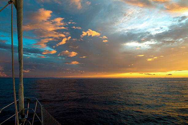 Dramatic sunset from bow of a sailboat Maui, Hawaii. stock photo