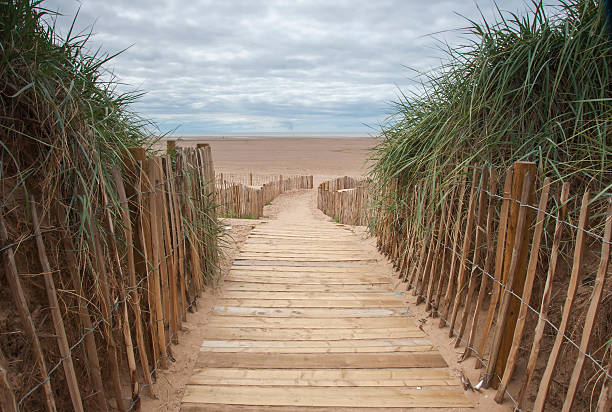 planked beach pathway wooden planked pathway to the beach at Lytham St Annes in northern england lytham st. annes stock pictures, royalty-free photos & images