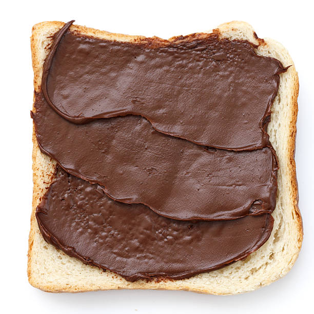 istock Chocolate nut spread on sliced white bread shot from above. 470790106