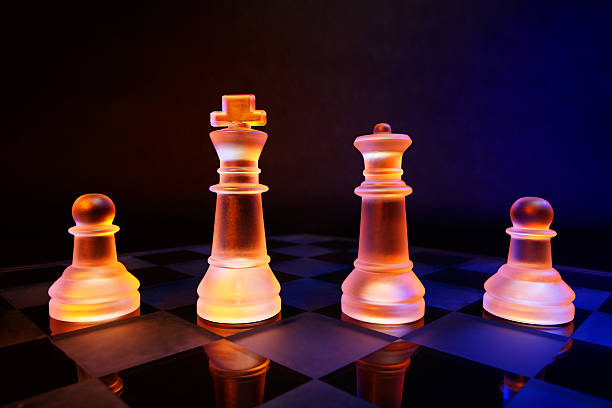 scacchiera con scacchi di vetro illuminato da luce blu e arancione - armed forces black yellow chess pawn foto e immagini stock