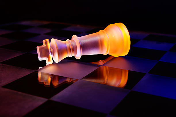 scacchiera con scacchi di vetro illuminato da luce blu e arancione - armed forces black yellow chess pawn foto e immagini stock