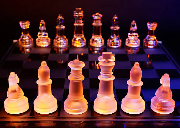 glas schach auf der schachbrett-hell blau und orange licht - armed forces black yellow chess pawn stock-fotos und bilder