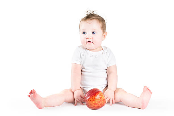 istock Adorable little baby playing with a big red apple 470795951
