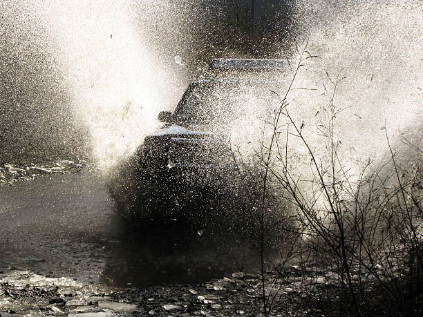 istock jeep passes through the water creating large spray of water 470797404