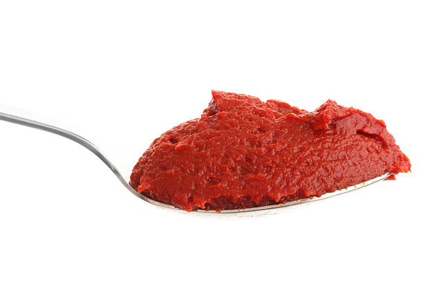 istock Spoon full of tomato paste on white background. 470797696