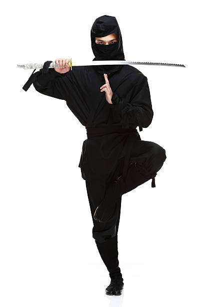 vista frontal de ninja en acción con espada - 20s standing one man only sword fotografías e imágenes de stock