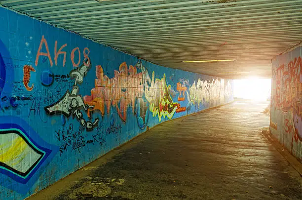 Photo of dark underpass tunnel with wand picture paintings and light