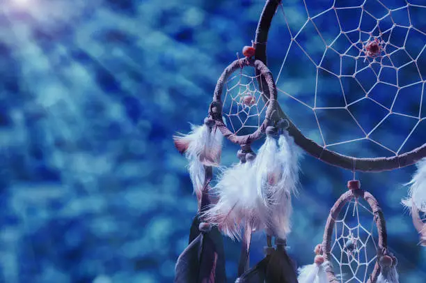dreamcatcher detail in the evening in front of blurry trees. Indian Summer. 