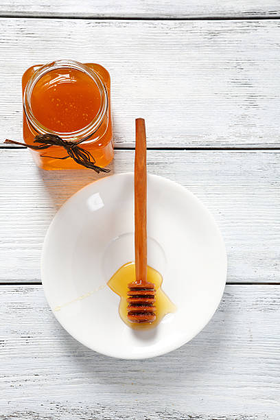 istock Sweet honey jar with a stick on plate 470802674