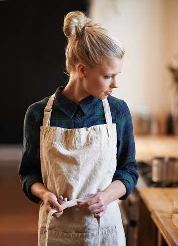 An attractive young woman  wearing an apron