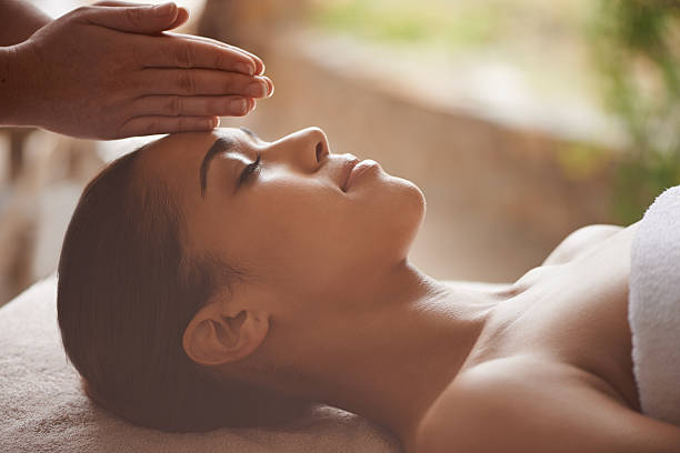 There's nothing better than a day at the spar Shot of a beautiful young woman getting a head massage at a spa relaxation lying on back women enjoyment stock pictures, royalty-free photos & images