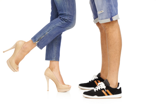 Cropped image of a man and woman's feet as they stand together in a romantic pose