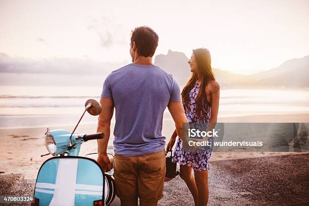 Loving Couple At The Beach With Their Scooter Stock Photo - Download Image Now - Motor Scooter, Beach, 20-29 Years