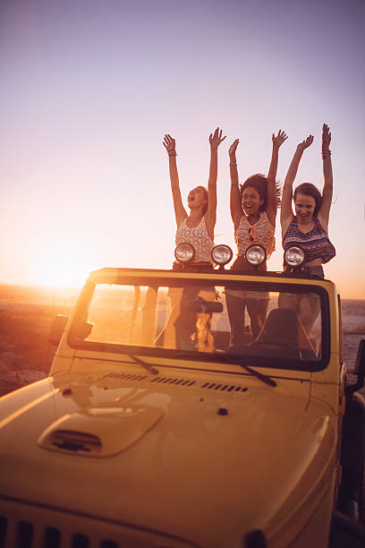 istock Girl friends dancing at sunset while on a road trip 470803540