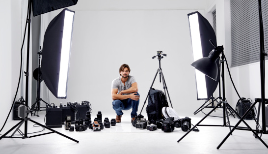 A professional photographer in his studio surrounded by equipment