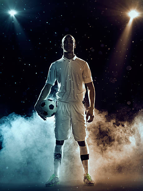 istock Soccer player holding a ball amidst smoke and spotlights 470808082