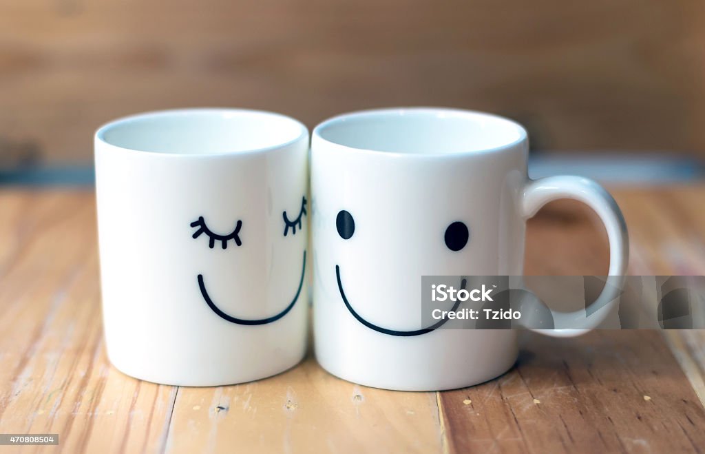 Two happy cups on wood table with bokeh, love concept Two happy cups on wood table with bokeh, about love concept 2015 Stock Photo