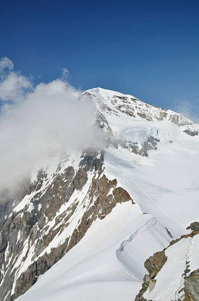 istock White Cloud in blue sky floats over snowy mountain 470813065