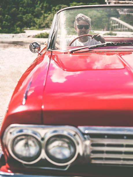 istock Happy young man in convertible car 470817968