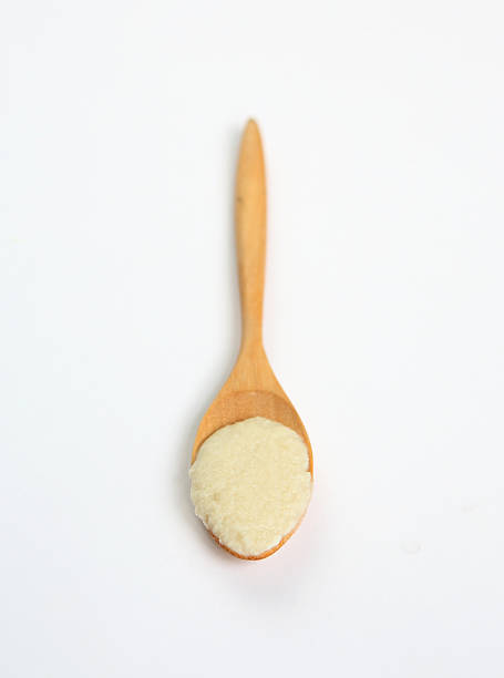 istock Powdered milk in wooden spoon over white background 470819270