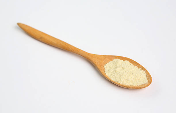 istock Powdered milk in wooden spoon over white background 470819644