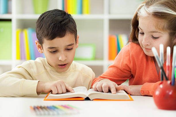 istock young brother and sister learn how to read at home 470826747