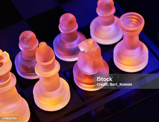 Glass Chess On Chessboard Lit By Blue And Orange Light Stock Photo - Download Image Now