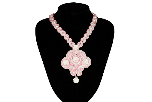 Pink beautiful necklace on a rack on white background