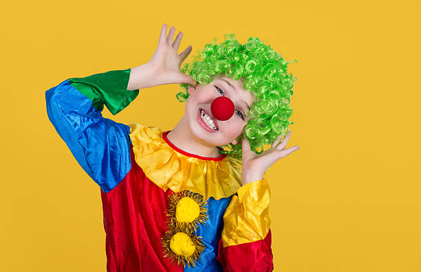 Funny clown isolated on yellow background. Closeup of little clown. Funny clown isolated on yellow background. Closeup of little clown in green wig. circus clown carnival harlequin stock pictures, royalty-free photos & images