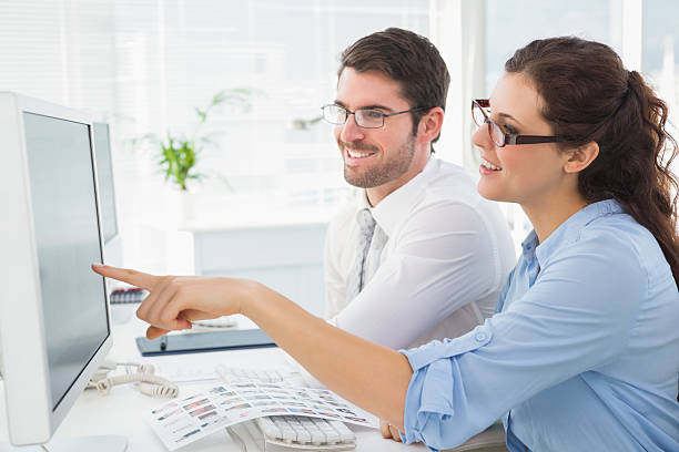 istock Smiling business coworkers pointing screen of computer 470829002