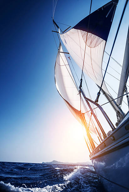 Sail boat in action Sail boat in action, summer adventure, luxury water transport, sunset light, active lifestyle, recreation in the sea, travel and tourism concept sailing ship stock pictures, royalty-free photos & images