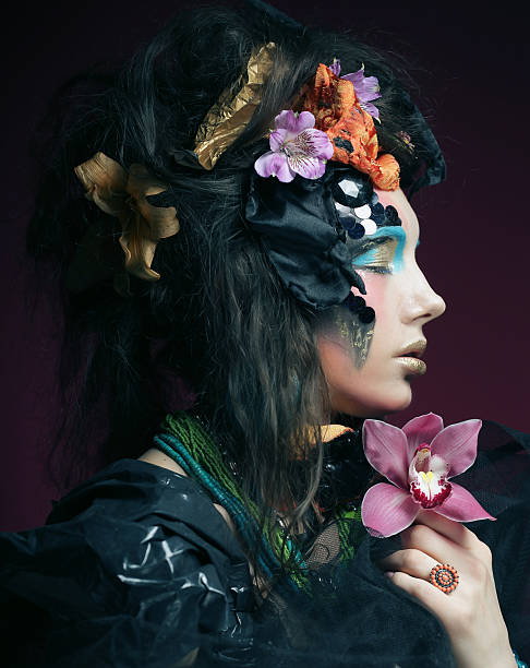 istock woman with creative make up holding pink flower 470834822