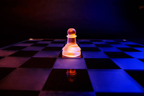 istock Glass chess on chessboard lit by blue and orange light 470836977