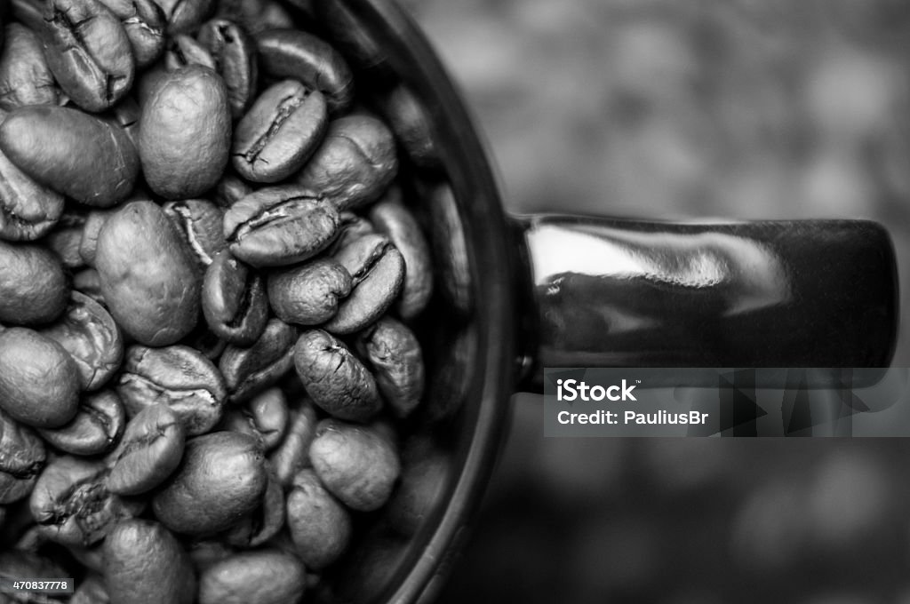 Cup of Coffee Cup full of coffee beans on black table covered with coffee beans 2015 Stock Photo