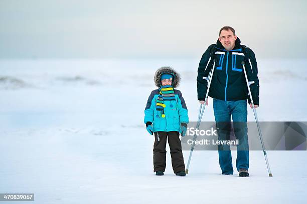 Crutches Hombre Con Su Hijo Y Caminando Al Aire Libre Foto de stock y más banco de imágenes de Adulto