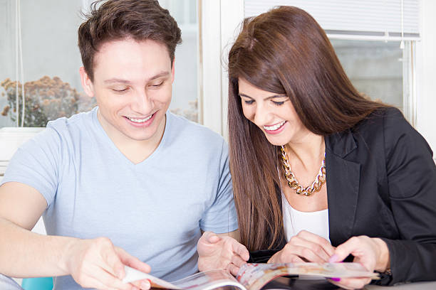 istock couple reading magazine and laughing 470839257