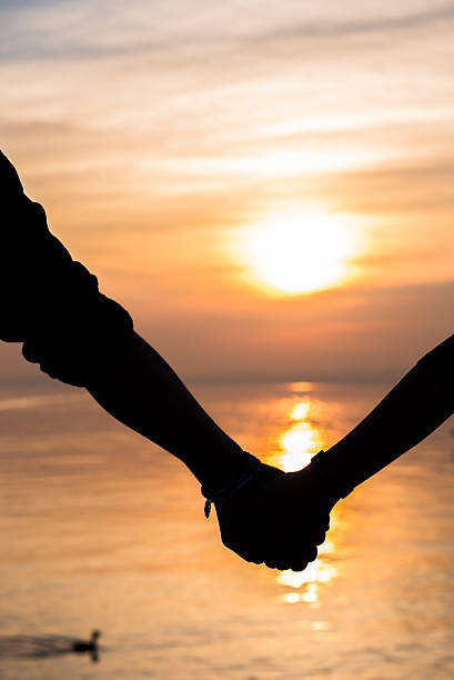 istock Bride and groom holding hands in front of a sunset 470842988