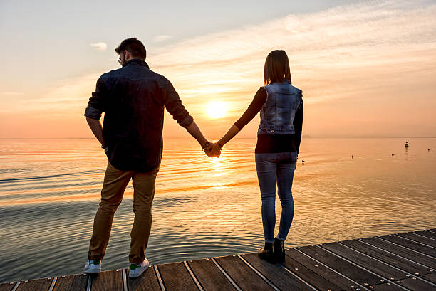 istock Bride and groom holding hands in front of a sunset 470843010