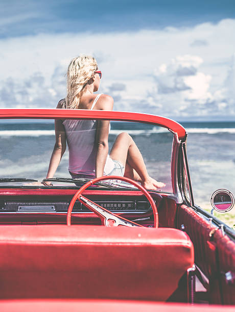 istock Happy young woman in convertible car 470846540