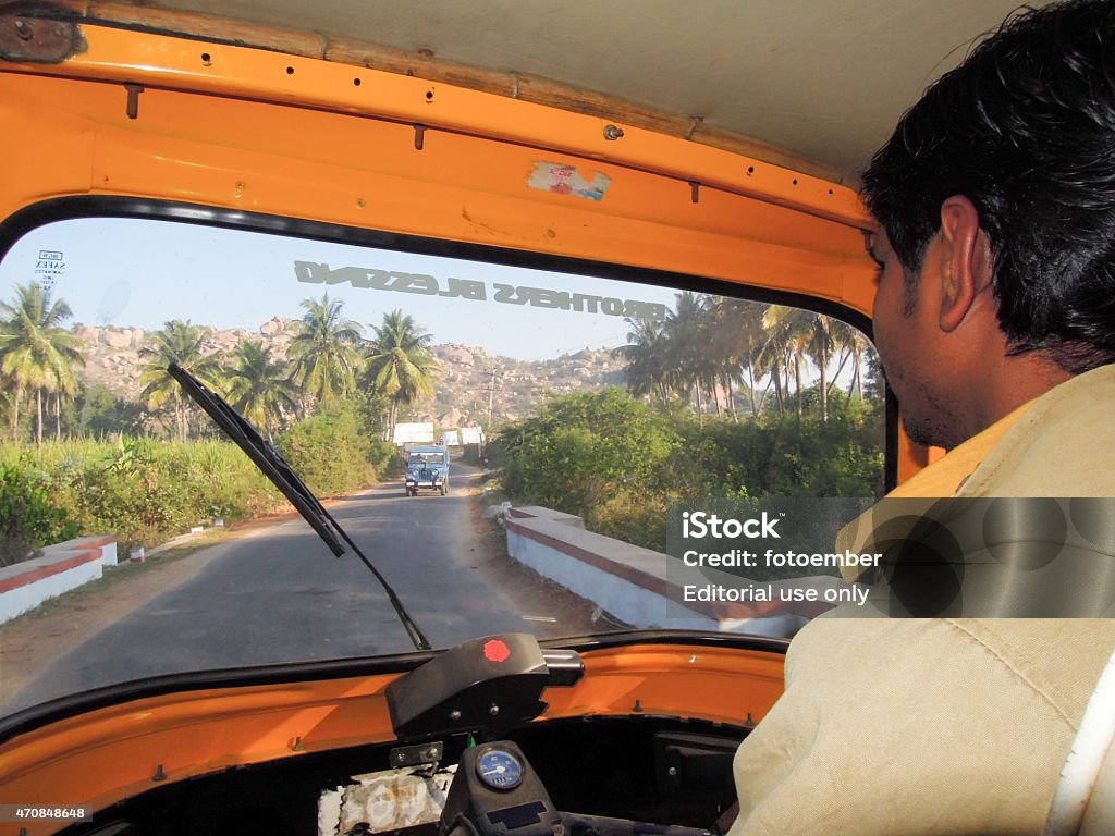 Driver of an auto rickshaw taxis on a road Hampi, India - 11 January 2015: Driver of an auto rickshaw taxis on a road at Hampi on India 2015 Stock Photo