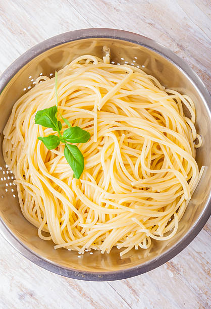 istock cooked pasta in the strainer on white wooden table 470850186