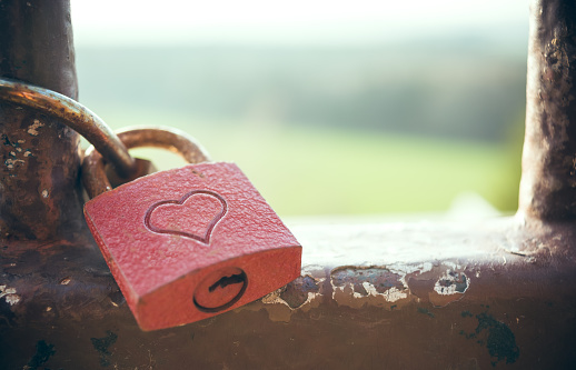 A rusty lock love with a red heart