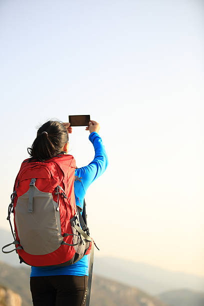istock hiking woman use smart phone taking photo 470855933