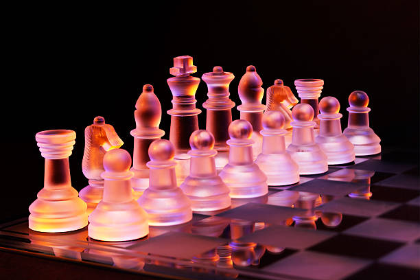 glas schach auf der schachbrett-hell blau und orange licht - armed forces black yellow chess pawn stock-fotos und bilder